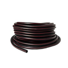 Svart och rd vakumslang ihoprullad i en rulle