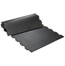 Svart pusselmnstrad gummimatta med knottrig yta, delvis upprullad och sammankopplad