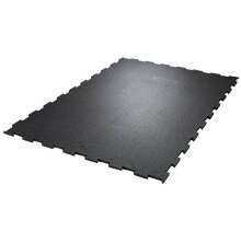 Svart gummimatta med pusselkanter och halkskyddsmnster, avsedd fr stall- eller industrigolv